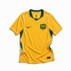 Fronte della maglia home dell'Australia 2026 oro con inserti verdi e stemma ufficiale ricamato sul petto
