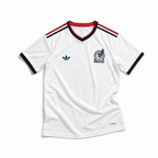 Maglia away Messico Coppa del Mondo 2026 — vista frontale, colore bianco con colletto a V in verde e rosso, stemma nazionale sul petto sinistro