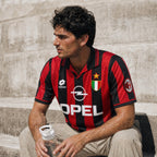 Fronte maglia Milan 1995/96 con strisce rosse e nere, colletto a polo e Scudetto.