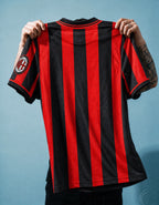 Dettaglio dello stemma del Milan con stella dorata e patch Scudetto tricolore.